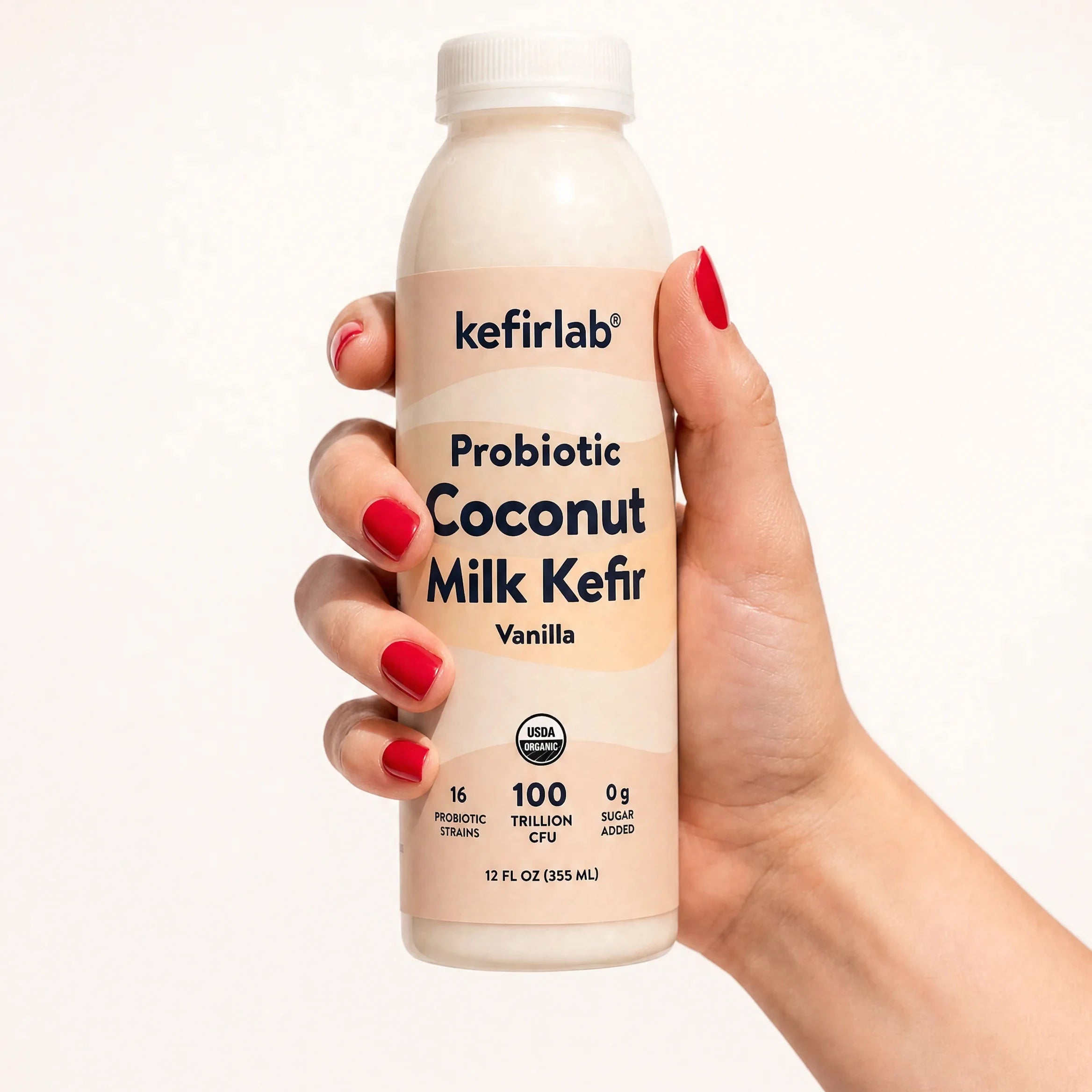 kefirlab probiotic coconut milk kefir vanilla bottle in hand, cream label front