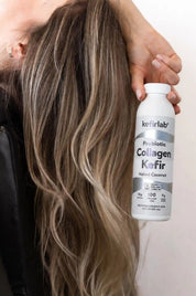 Probiotic collagen kefir bottle by kefirlab, held near long hair, Naked Coconut